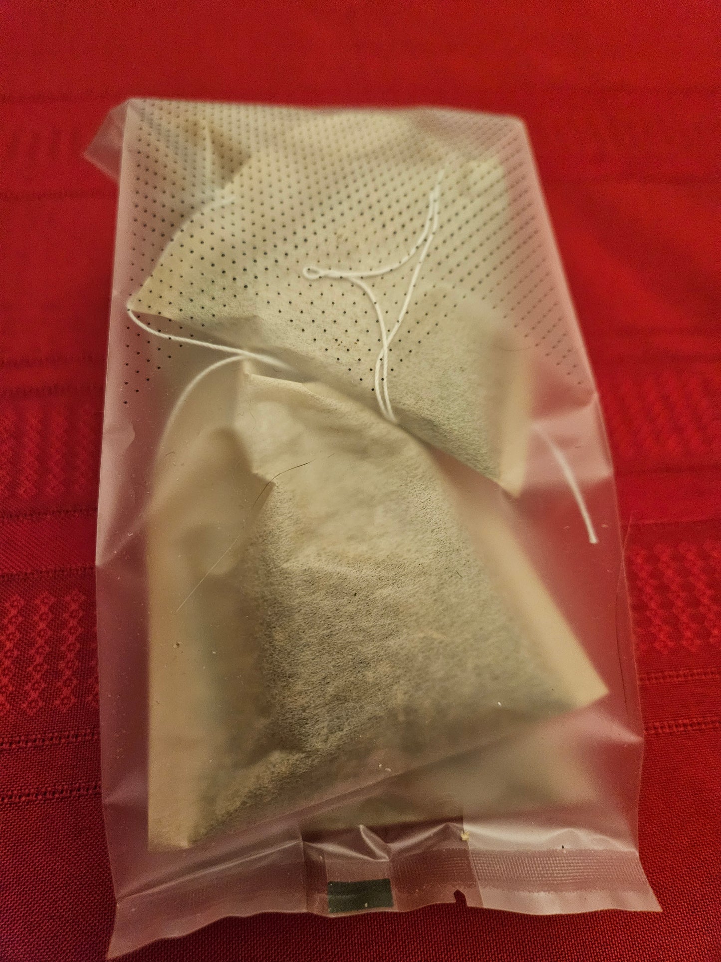 Catnip Tea bags in a clear plastic bag on a red background