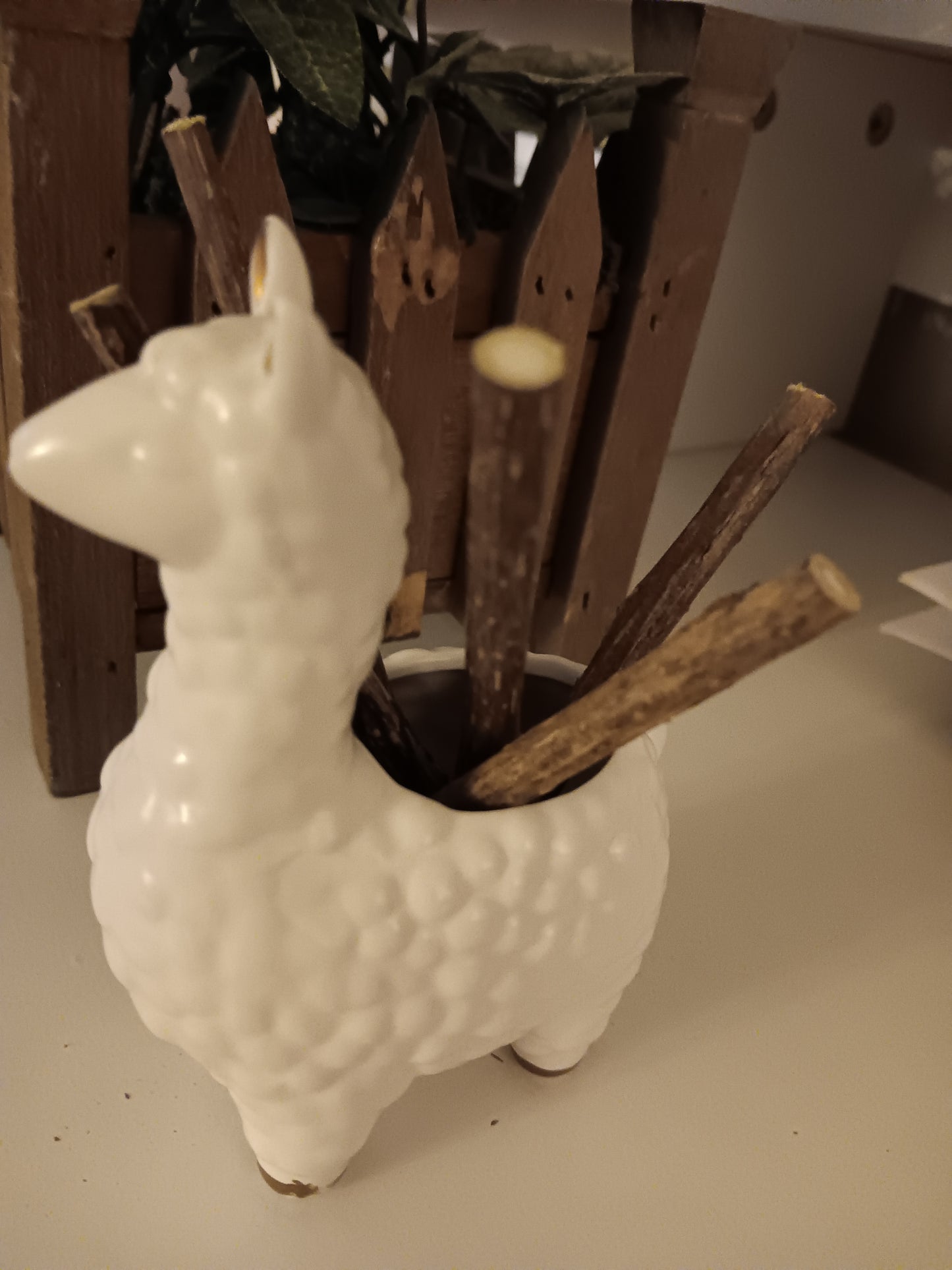 White ceramic deer figure with wooden high quality organic silvervine sticks on a neutral background